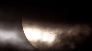 O que é aquele ponto no Sol? É o resultado de um tipo incomum de eclipse solar, ocorrido em 2006. Normalmente, é a Lua que eclipsa o Sol. Desta vez, foi o planeta Mercúrio. Assim como a aproximação da Lua Nova, antes de um eclipse solar, a fase de Mercúrio tornou-se uma faixa iluminada cada vez mais fina, à medida que o planeta progredia em direção a um alinhamento com o Sol. Na sequência, a fase de Mercúrio caiu para zero e a mancha escura de Mercúrio cruzou nossa estrela-mãe. A situação poderia tecnicamente ser rotulada como um eclipse anular de Mercúrio, mas com um anel de fogo extraordinariamente grande. Horas depois, enquanto Mercúrio continuava em sua órbita, uma leve faixa iluminada apareceu novamente - Foto Nasa