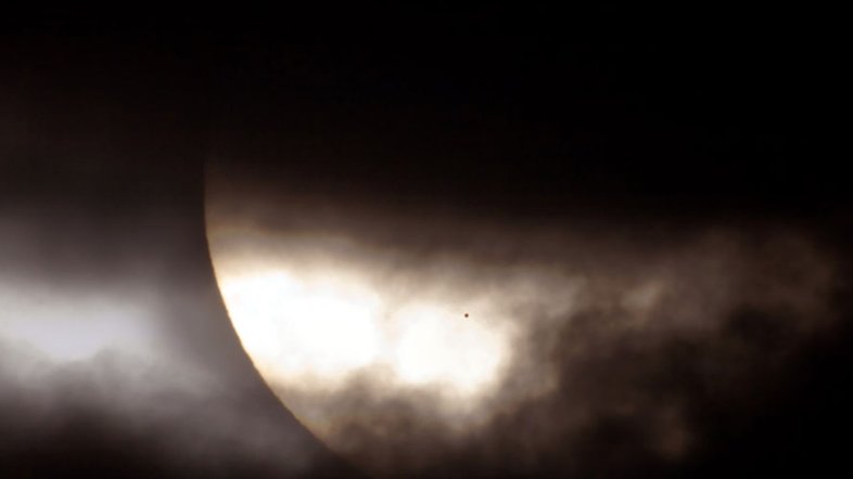 O que é aquele ponto no Sol? É o resultado de um tipo incomum de eclipse solar, ocorrido em 2006. Normalmente, é a Lua que eclipsa o Sol. Desta vez, foi o planeta Mercúrio. Assim como a aproximação da Lua Nova, antes de um eclipse solar, a fase de Mercúrio tornou-se uma faixa iluminada cada vez mais fina, à medida que o planeta progredia em direção a um alinhamento com o Sol. Na sequência, a fase de Mercúrio caiu para zero e a mancha escura de Mercúrio cruzou nossa estrela-mãe. A situação poderia tecnicamente ser rotulada como um eclipse anular de Mercúrio, mas com um anel de fogo extraordinariamente grande. Horas depois, enquanto Mercúrio continuava em sua órbita, uma leve faixa iluminada apareceu novamente - Foto Nasa