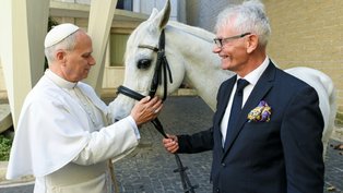 Papa Leão XIV (à esquerda) recebendo Proton, um cavalo puro-sangue árabe branco, das mãos do polonês Andrzej Michalski (à direita - VATICAN MEDIA/AFP