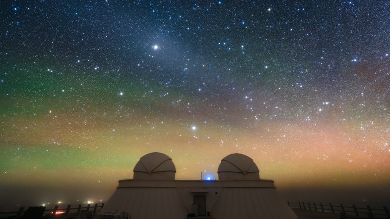 No último dia 21 de setembro, Saturno estava em oposição ao Sol, no céu. Na posição mais próxima à Terra, Saturno também estava em seu ponto mais brilhante do ano, nascendo enquanto o Sol se punha, ficando acima do horizonte durante toda a noite, entre as estrelas da Constelação de Peixes. Nesta foto do Observatório Qinghai Lenghu, no Planalto Tibetano, sudoeste da China, o planeta aparece como o ponto mais brilhante, na parte superior e ligeiramente à esquerda. Saturno está imerso em uma tênue e difusa luz oval, conhecida como gegenschein - que significa “brilho de oposição”, em alemão -, um efeito astronômico produzido pela luz solar retroespalhada pela poeira interplanetária. O forte brilho atmosférico também forma um fundo colorido no horizonte da paisagem