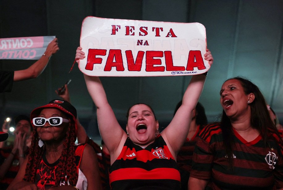 Torcedores do Flamengo reagem enquanto assistem ao jogo em telões no estádio do Maracanã