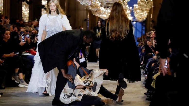 Manifestante tumultua desfile da Louis Vuitton em Paris em protesto contra consumo excessivo