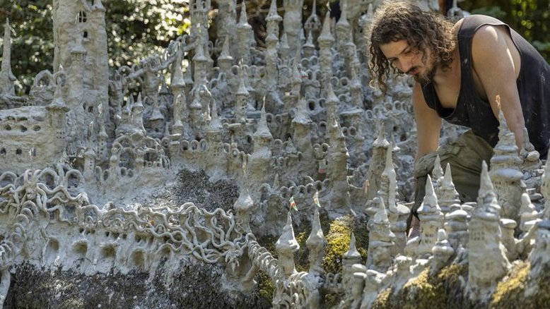 Artista suíço esculpe extenso castelo de argila em margem de rio seco