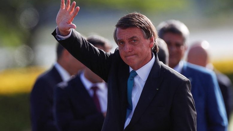 Presidente Jair Bolsonaro acena durante cerimõnia de hasteamento da bandeira no Palácio da Alvorada, em Brasília